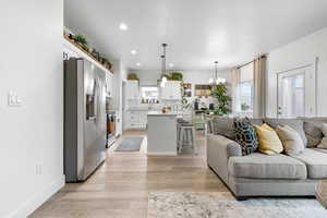 Living room featuring recessed lighting, light wood-type flooring, and a chandelier