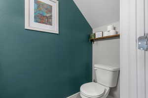 Bathroom featuring a textured ceiling and lofted ceiling