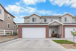 View of front facade featuring brick siding, a garage, and driveway
