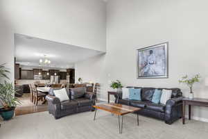 Living area with a chandelier, a towering ceiling, recessed lighting, and light wood-type flooring