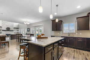 Kitchen with light wood-style floors, a kitchen breakfast bar, backsplash, a textured ceiling, and recessed lighting