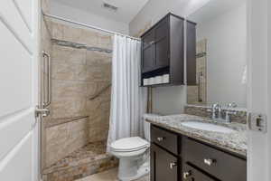 Bathroom with vanity, a tile shower, and tile patterned flooring