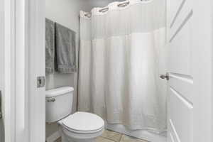 Full bath with toilet and tile patterned flooring