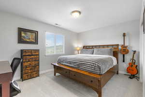 Bedroom featuring light carpet and an office area
