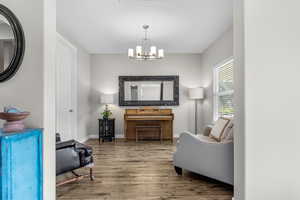Sitting room featuring wood finished floors and a chandelier
