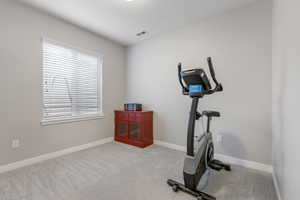 Workout area featuring carpet and baseboards