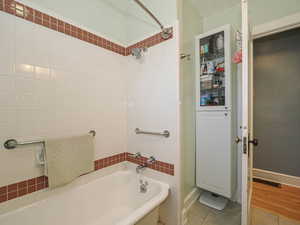 Bathroom featuring tile patterned floors and tub / shower combination