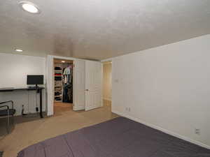 Unfurnished bedroom featuring a spacious closet, a closet, and carpet flooring