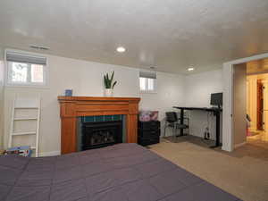 Carpeted bedroom featuring a fireplace and recessed lighting