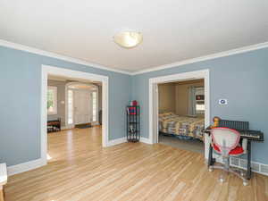 Bedroom with light wood-type flooring and ornamental molding