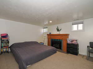 Carpeted bedroom featuring a fireplace and baseboards