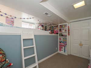 Bedroom featuring a textured ceiling, carpet flooring, and a closet