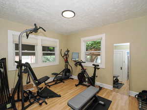 Exercise room with wood finished floors and baseboards
