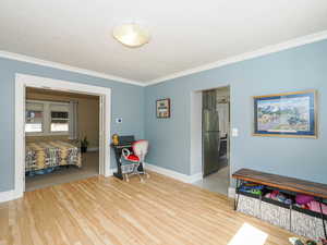 Office area with ornamental molding and light wood-style flooring