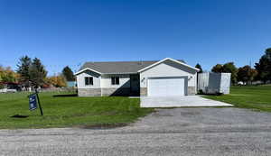 Single story home with driveway, stone siding, an attached garage, and a shingled roof