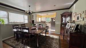 Dining space featuring a chandelier, crown molding, and wood finished floors
