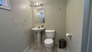 3/4 bath with toilet, shower, and tile patterned flooring