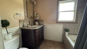 Full bathroom with a wainscoted wall, vanity, and tile patterned floors