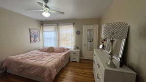 Bedroom with dark wood-style flooring and a ceiling fan