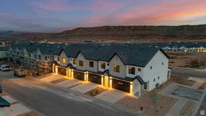 View of front of home with a garage, stucco siding, driveway, and a mountain view