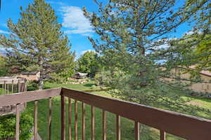 View of grassy yard featuring a balcony
