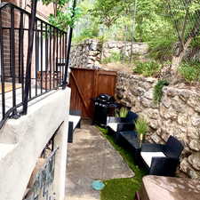 View of side fenced yard.  The stairs from the lower unit lead to this area.