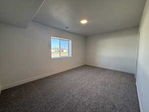 Carpeted empty room with baseboards and recessed lighting