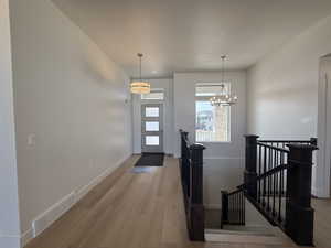 Foyer entrance with light wood-type flooring, a chandelier, and a textured ceiling