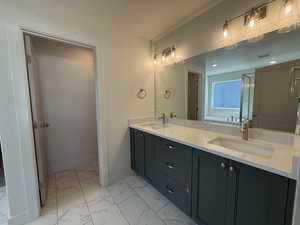 Full bathroom featuring double vanity and marble look tiles