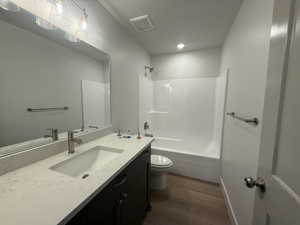 Full bath featuring wood finished floors, vanity, bathtub / shower combination, and recessed lighting