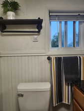 Bathroom featuring toilet and wainscoting