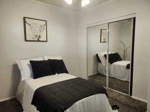 Primary Bedroom featuring carpet flooring, mirrored closet, and ceiling fan