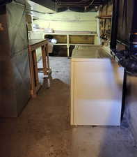 Unfinished basement with washer / clothes dryer and heating unit