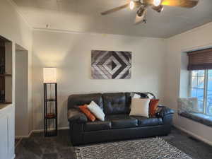 Spacious living room with ceiling fan and large front window/bench seat