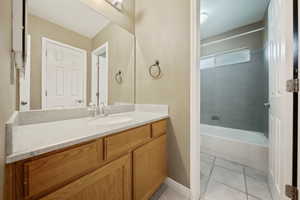 Bathroom with vanity, bathing tub / shower combination, and tile patterned floors