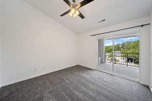 Empty room with vaulted ceiling, carpet, and ceiling fan