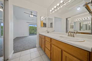 Full bathroom featuring double vanity, a ceiling fan, and tile patterned flooring