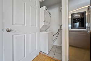 Laundry area featuring stacked washer / dryer and light tile patterned floors