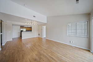 Unfurnished living room featuring rail lighting and light wood-style floors