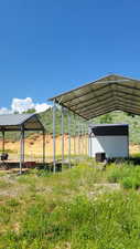 View of car parking featuring a storage unit and a detached carport