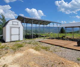 View of yard featuring a storage shed, a mountain view, and a carport