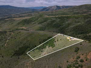 Aerial overview of property's location with a mountainous background and property boundaries highlighted