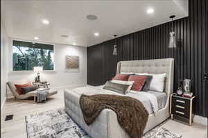 Bedroom with an accent wall, recessed lighting, and wood finished floors