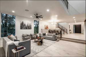 Living room with recessed lighting, a chandelier, light wood-type flooring, and ceiling fan