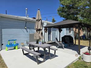 View of patio with a gazebo and outdoor dining space