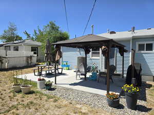 Rear view of property featuring a gazebo and a patio area