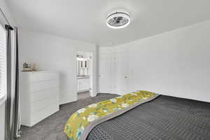 Bedroom with dark colored carpet and ensuite bath