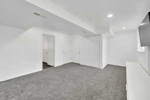 Finished below grade area with dark carpet and recessed lighting