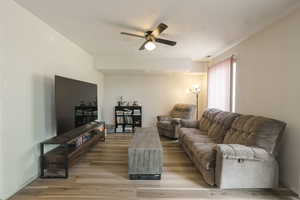 Living room featuring ceiling fan and light wood finished floors