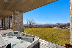 View of patio with a mountain view, a hot tub, and grilling area